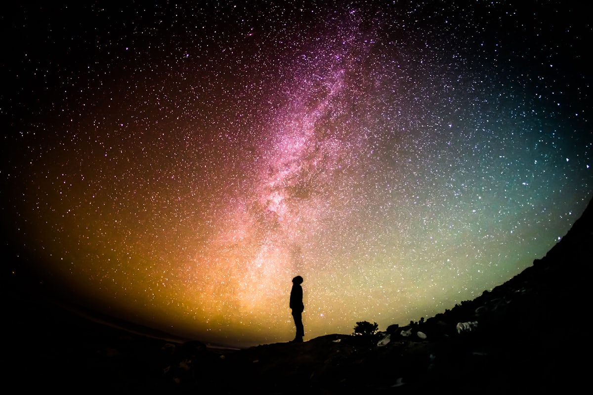 A lone figure standing beneath the Milky Way